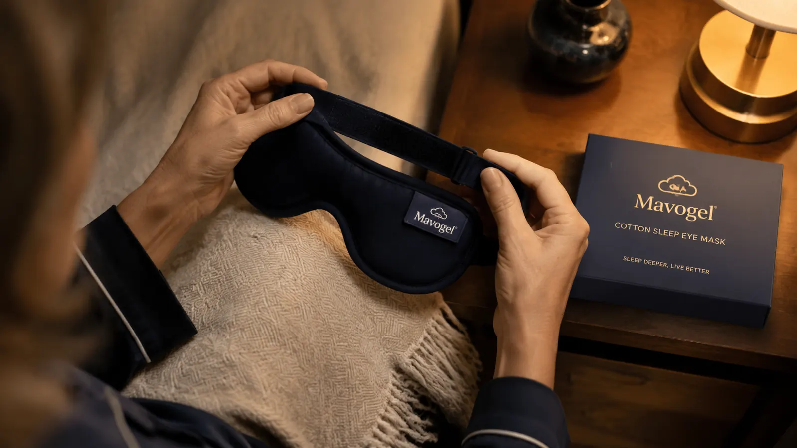 Close-up of a person adjusting the strap of the Mavogel cotton sleep mask before putting it on